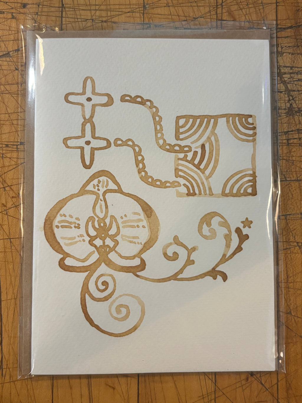 Hand-painted espresso card with cat and ornamental designs in a plastic sleeve
